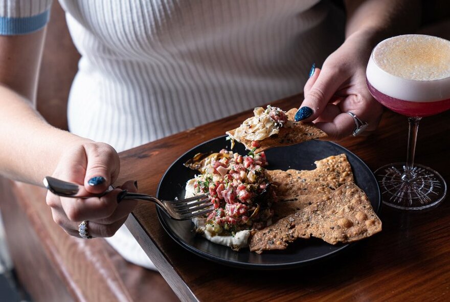 Person eating bruschetta.