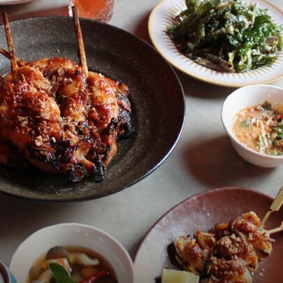 Thai dishes in bowls on a restaurant dining table.