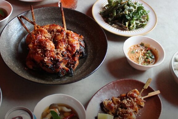 Thai dishes in bowls on a restaurant dining table.