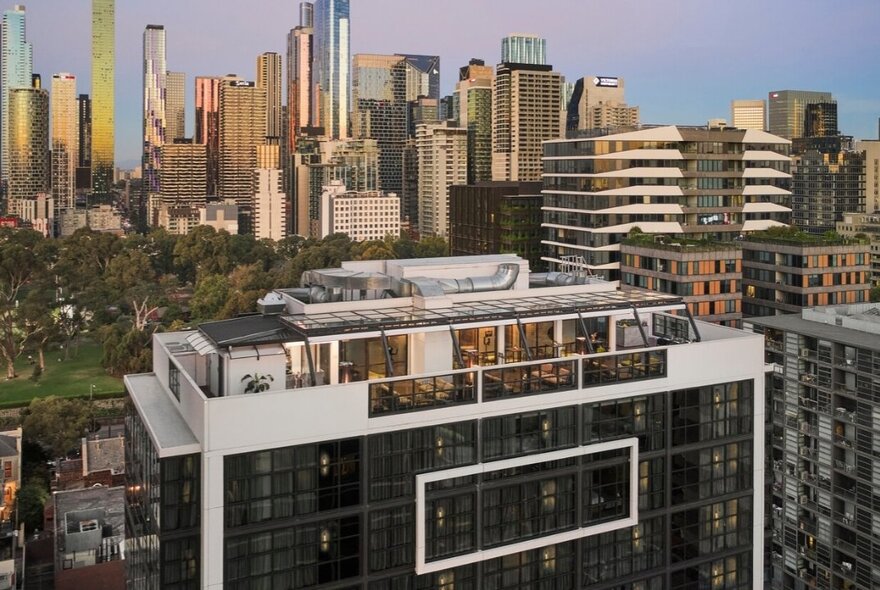 A portion of the Melbourne city skyline and the rooftop of the Courtyard by Marriott Melbourne Flagstaff Gardens hotel in the foreground.