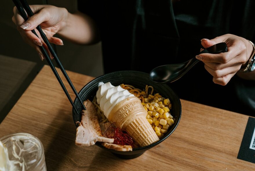 A bowl of ramen with a soft serve ice cream in it