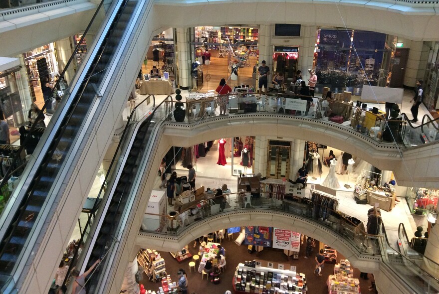 Inside Collins234 shopping centre, showing several levels of shopping, connected by escalators.