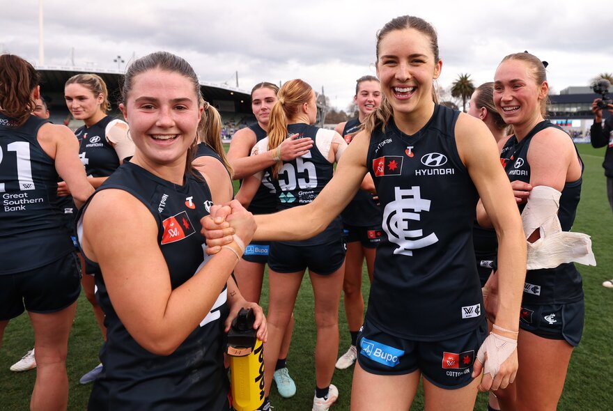 AFLW Carlton players congratulating each other after a win on the ground. 