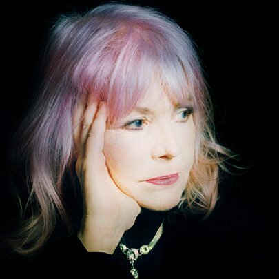 Singer Margie Lou Dyer looking to one side, her head is resting on her hand, she has light coloured hair framing her face.