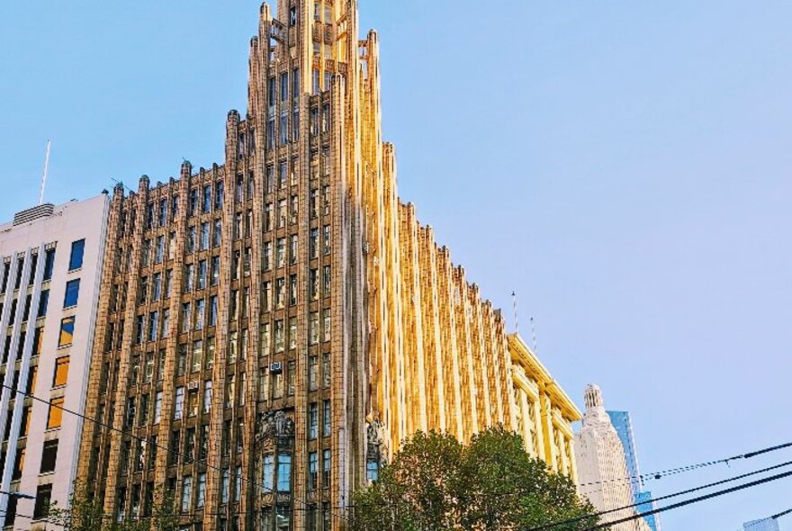 A gothic building in central Melbourne, seen from the lower right corner, with blue sky behind it.