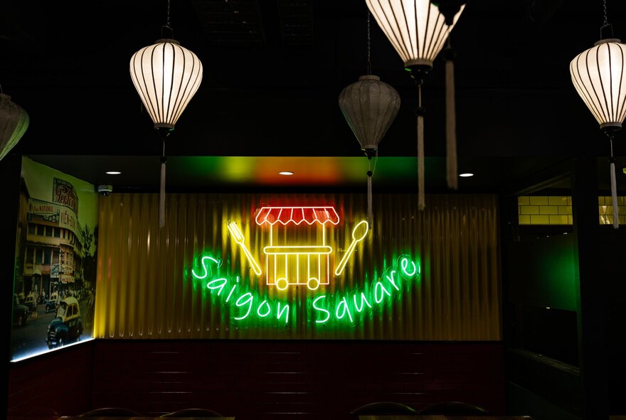 The neon sign inside Saigon Square, Vietnamese eatery in Melbourne, with white paper lanterns.