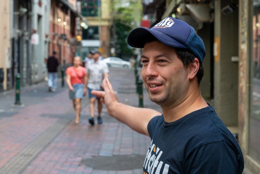 A Fit City tour guide pointing down a Melbourne laneway.