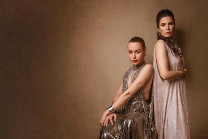 Models against beige/brown background wearing brown-hued formal gowns.