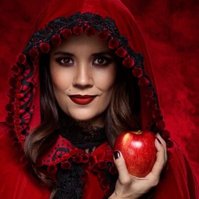 Woman wearing a red cloak, holding a red apple.