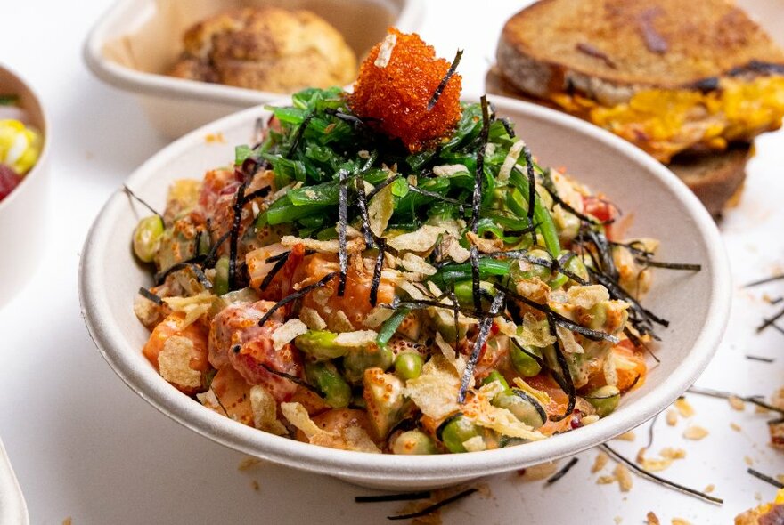 Salad bowl with greens, vegetable, rice and a garnish.