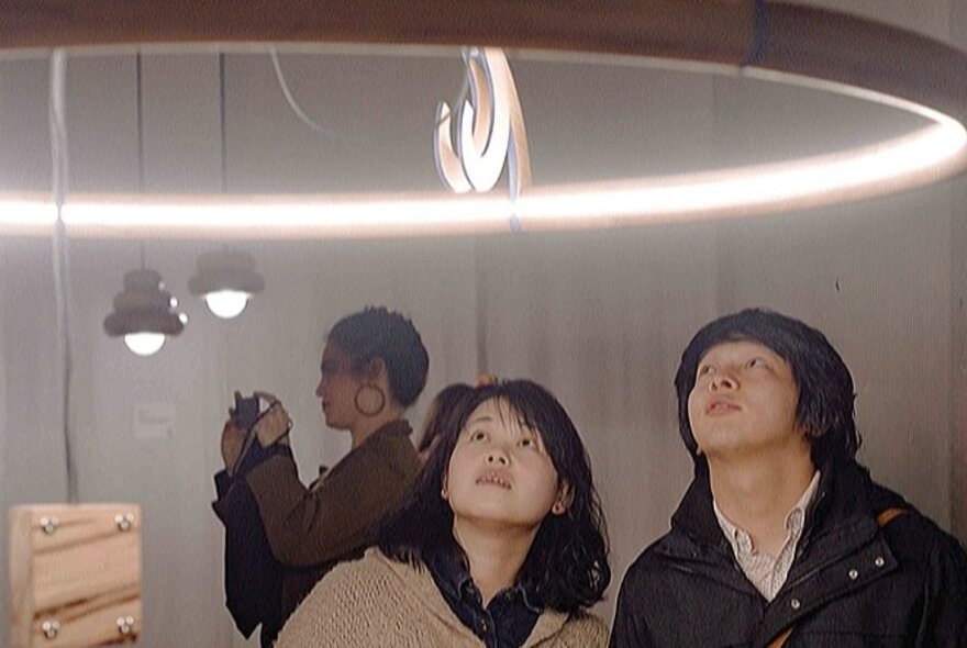People looking at objects in a gallery space.