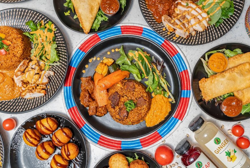 African dishes on colourful plates including rice and patties.