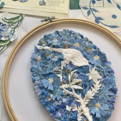 Detail of an embroidery of a bird with flowers.