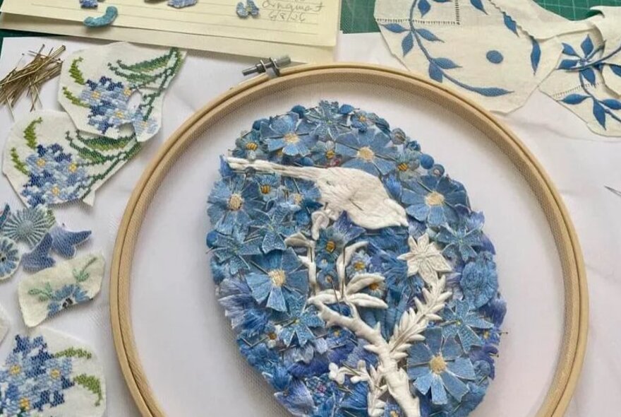 Detail of an embroidery of a bird with flowers.