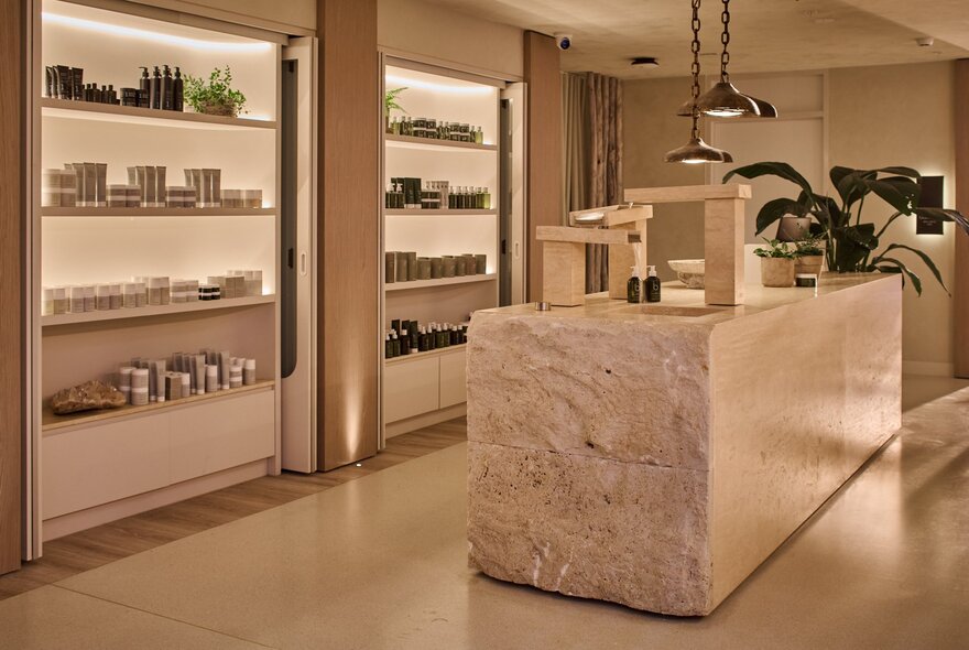 The Bamford Wellness Spa at 1 Hotel, with a central service counter and shelves of products on display against a wall.