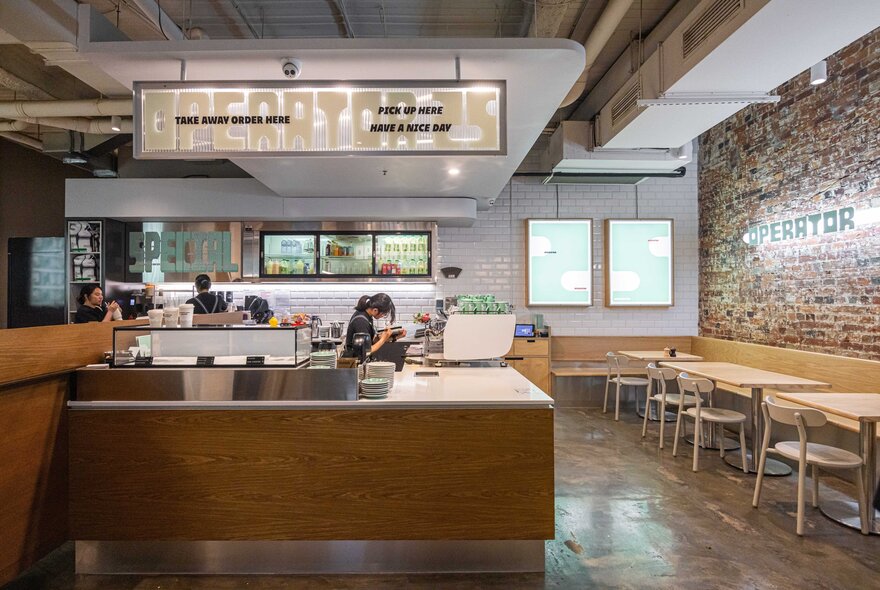 Interior of the cafe Operator 25 with a counter and tables along the wall. 