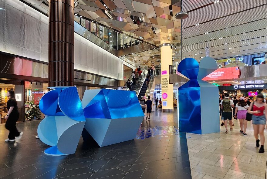 A giant blue bon bon broken in two inside a shopping mall.