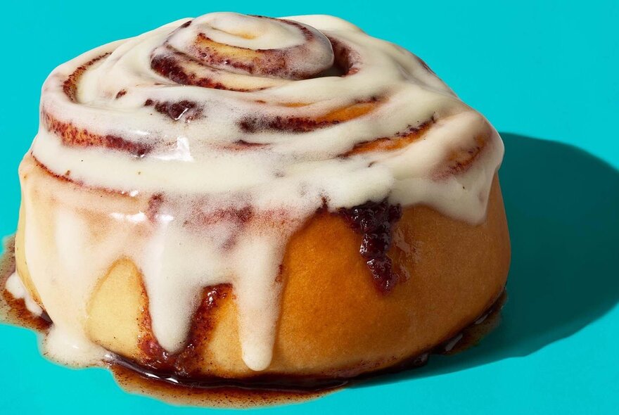A cinnamon bun dripping with icing.