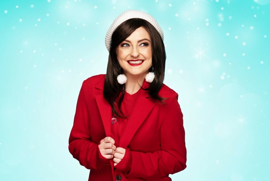 Performer dressed in a red suit with white hat and snowball earrings against a sparkling turquoise sky.