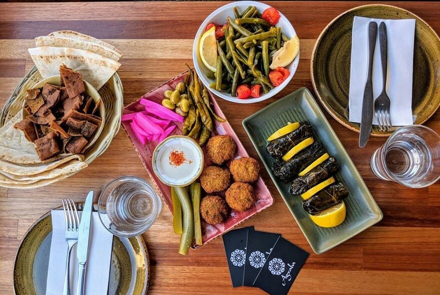 Plates of Lebanese entrees including falafel balls and beans.