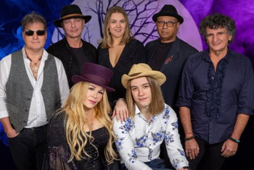 A band of singers and musicians in a group photo.