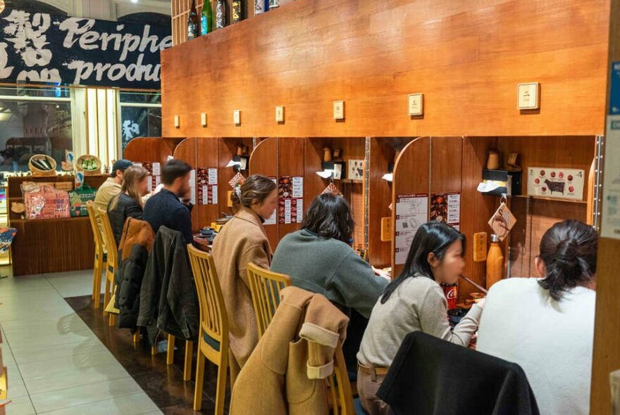 People sitting at booths in a restaurant