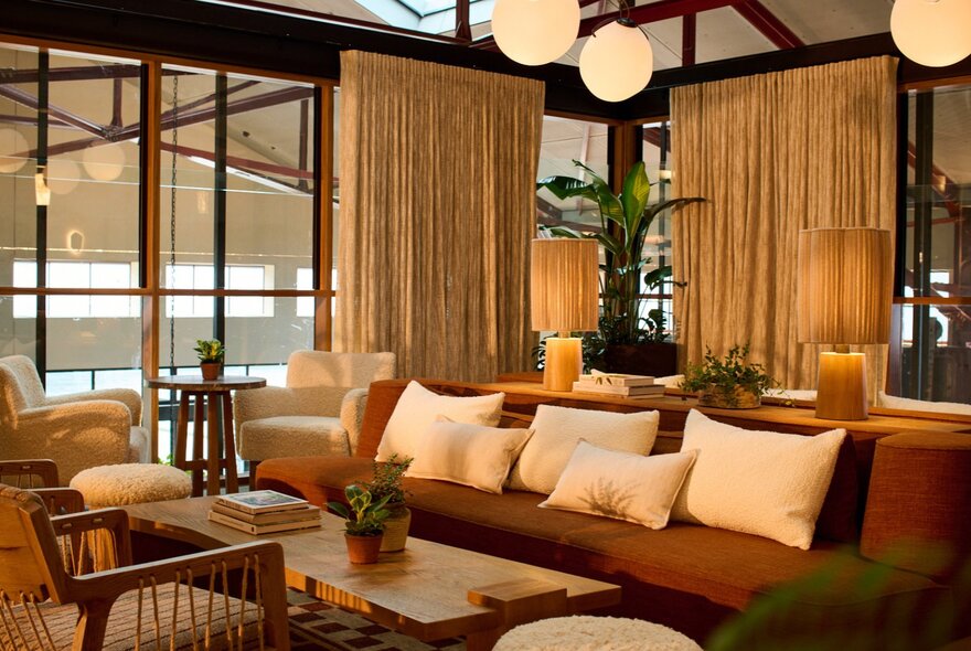 Couches, lamps, and low table offering a comfortable space at Upstairs, the bar at 1 Hotel Melbourne.