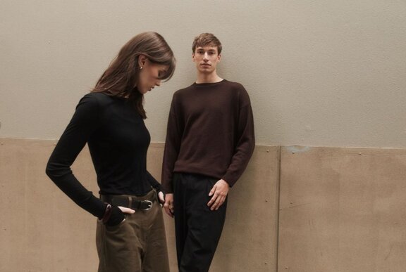Two young models wearing brown winter clothing.