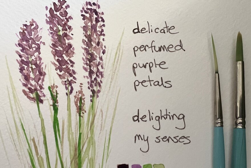 A page from a sketching journal, with a drawing of purple flowers, some notes handwritten in black ink alongside, and two brushes resting on the white page.
