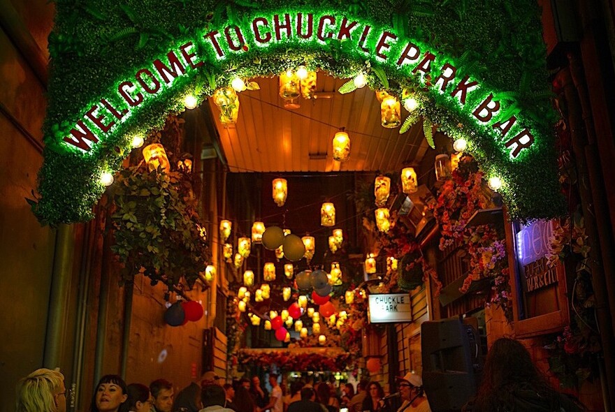 Small outdoor bar in a laneway at night with hanging lanterns.