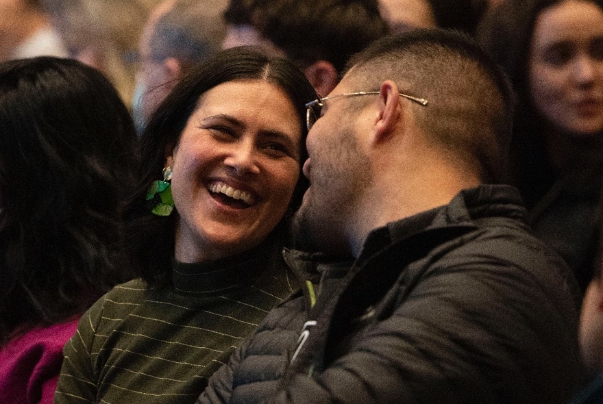 Two people turned towards each other sharing a joke. 