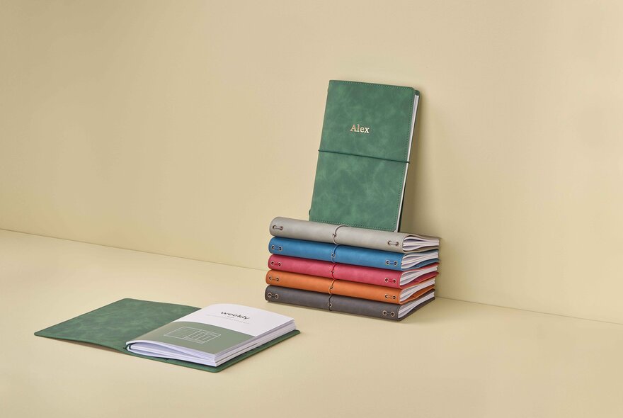 Small stack of different coloured journals.