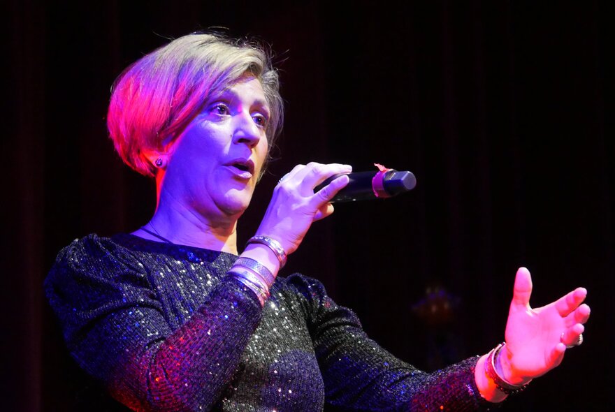 Acclaimed French chanteuse Noria Letts singing into a microphone.