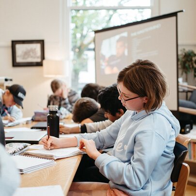 Students working at desks in a classroom setting. 