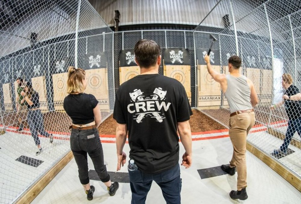 Three people throwing axes for recreation.