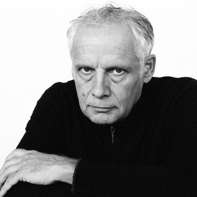 Dutch  cellist Pieter Wispelwey looking stern with arms folded, wearing a black jumper.