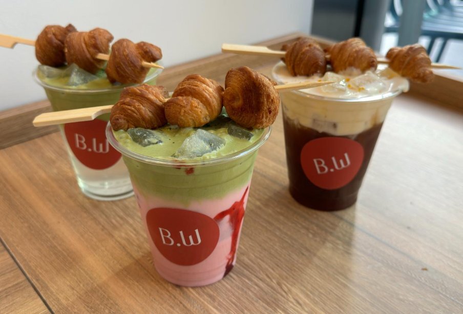 Three drinks topped with mini croissants