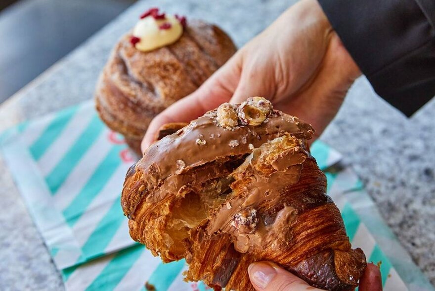 Person holding a chocolate pastry.