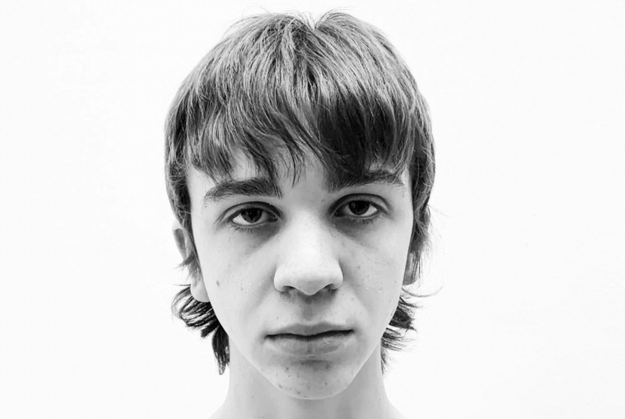 A black and white head shop of a young man with a shaggy fringe. 
