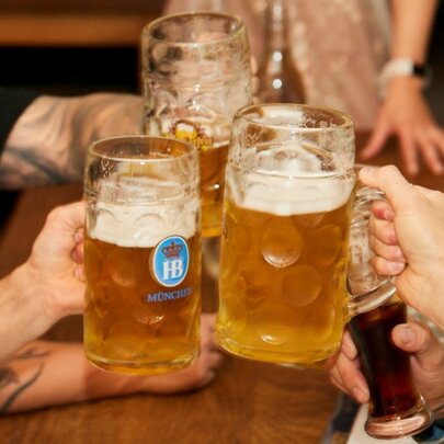 three large steins of beer being clinked