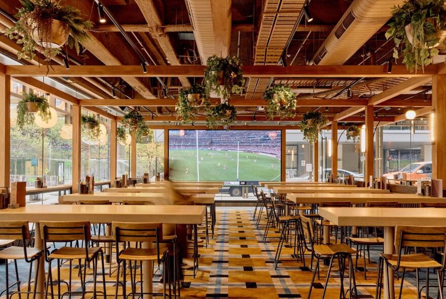 Dining room with large tv playing football