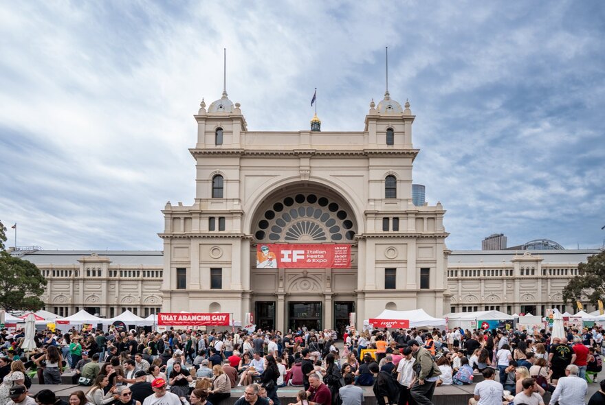 Crowds gathered at market stalls in front of the Exhibition Building.