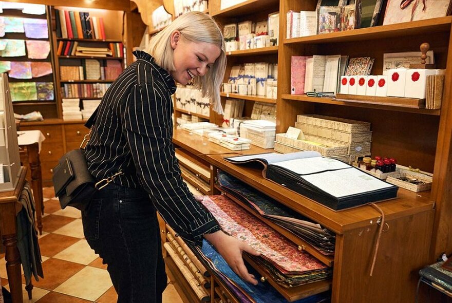 Person selecting wrapping paper in a stationery store.