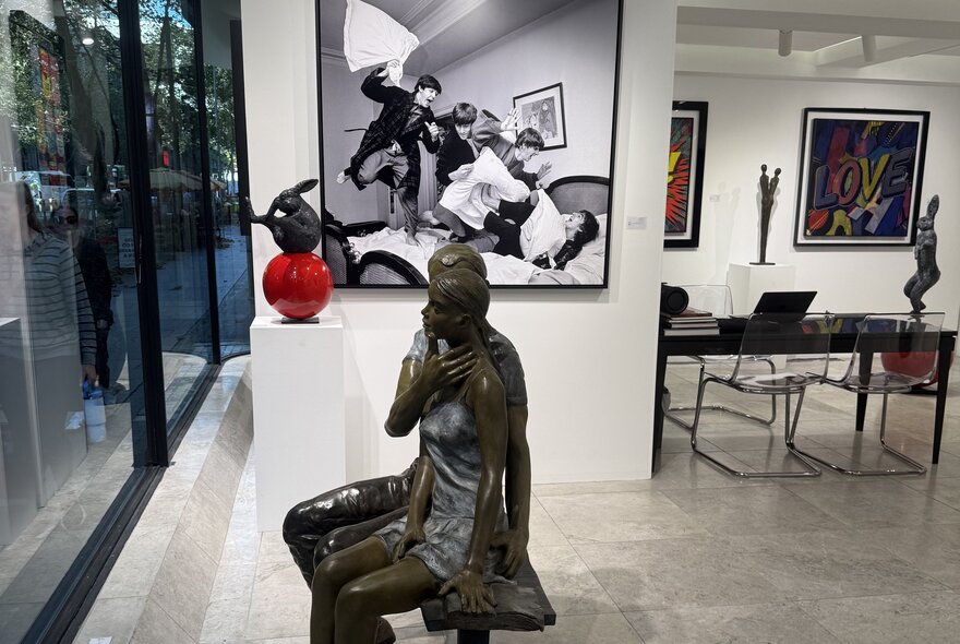 A display of hanging and standing artwork in a gallery setting.