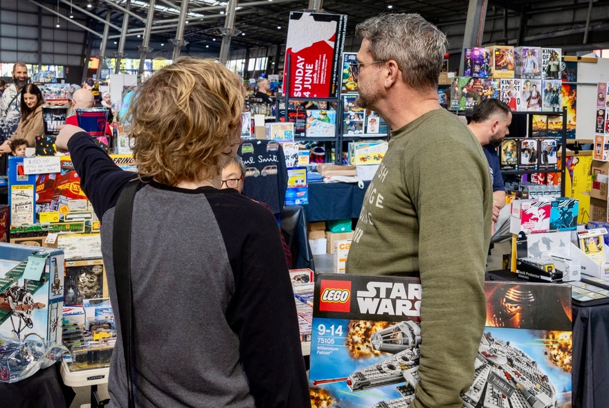 People looking at a market stall at a toy collectors fair.