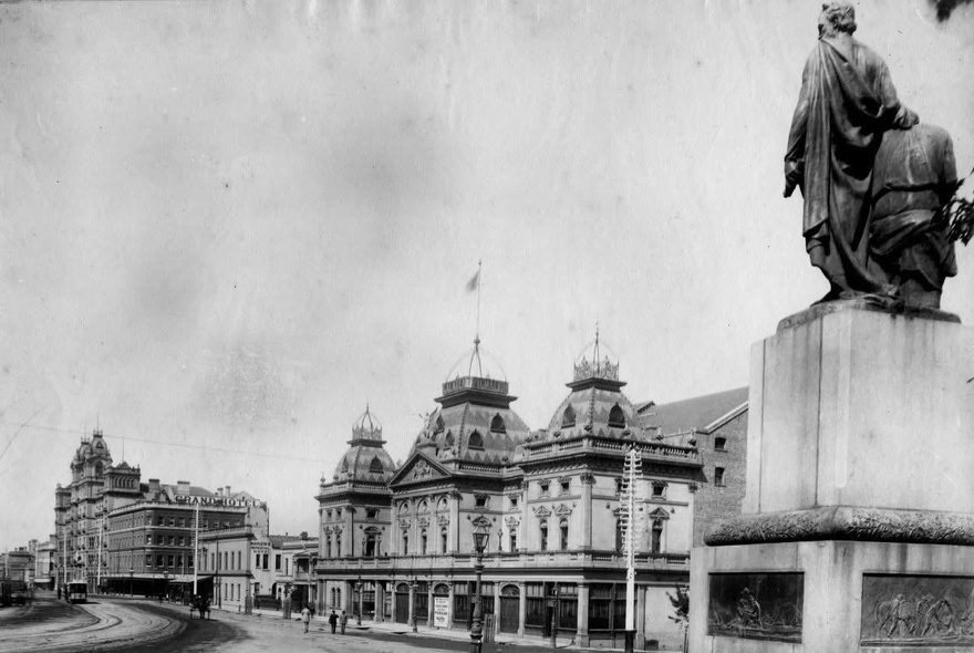 Early Melbourne image of a statue on a pedestal outside a theatre on a still-to-be-built Spring Street.