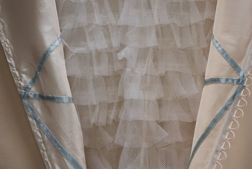 An open bodice revealing layers of ruffled tulle underneath.
