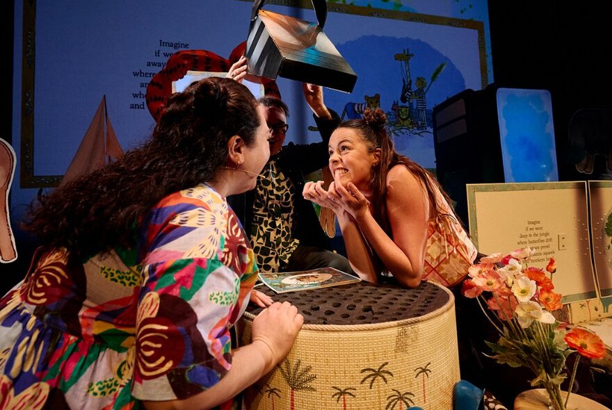 Two performers on stage with props.