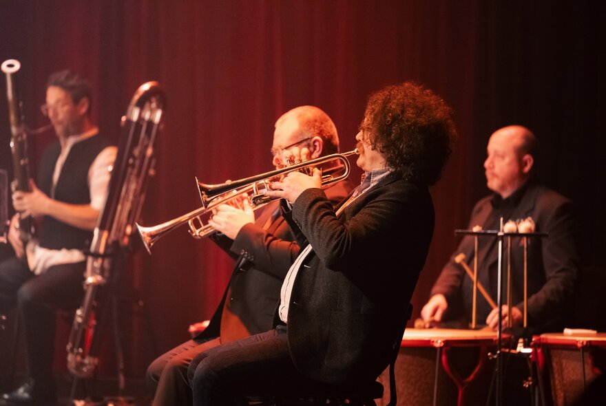 Musicians playing trumpets in an orchestra.