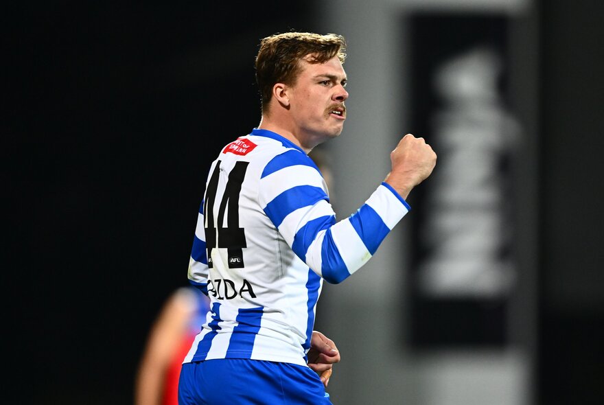 North Melbourne AFL player making a fist during a game.